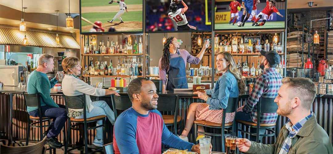 People being served in restaurant with sports on TV